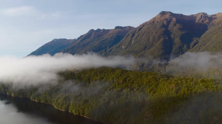 An aerial view of clouds over a river and hillside