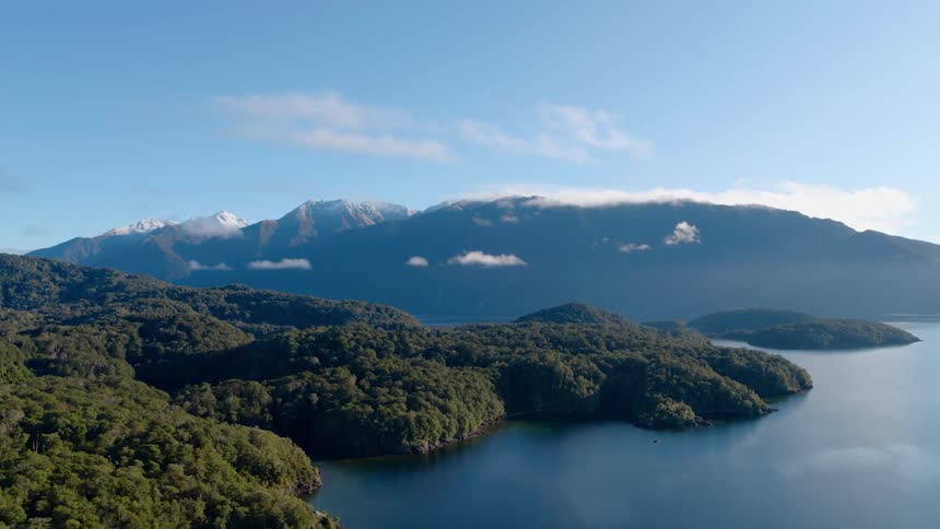 Dense forests and tall mountains sit along the coast of the ocean