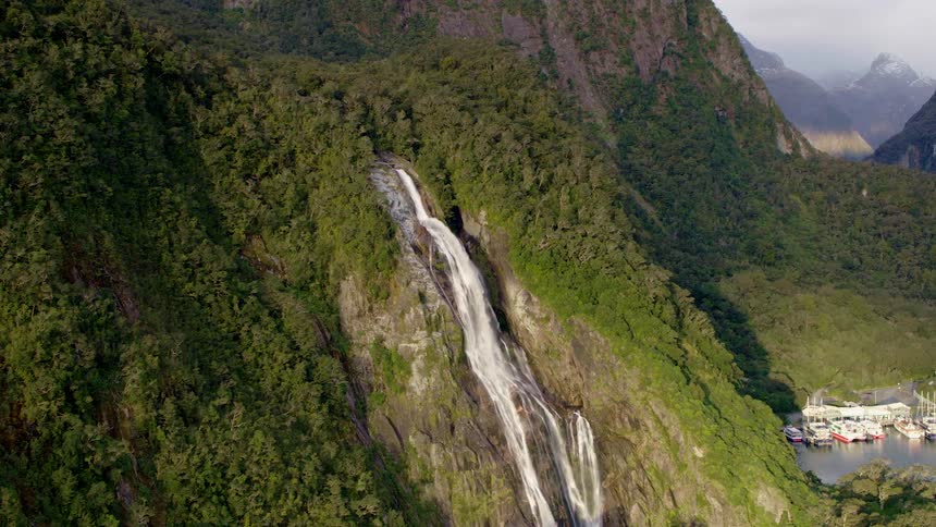 An aerial view of a waterfall flowing over a tall mountainside in the wilderness