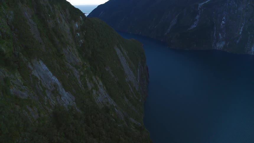 The water is calm between the mountains