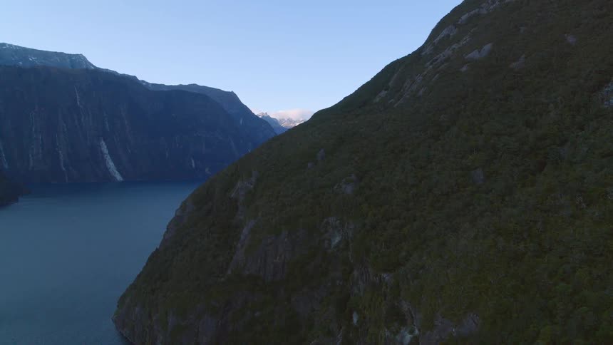 Aerial view of mountains next to a water source is displayed