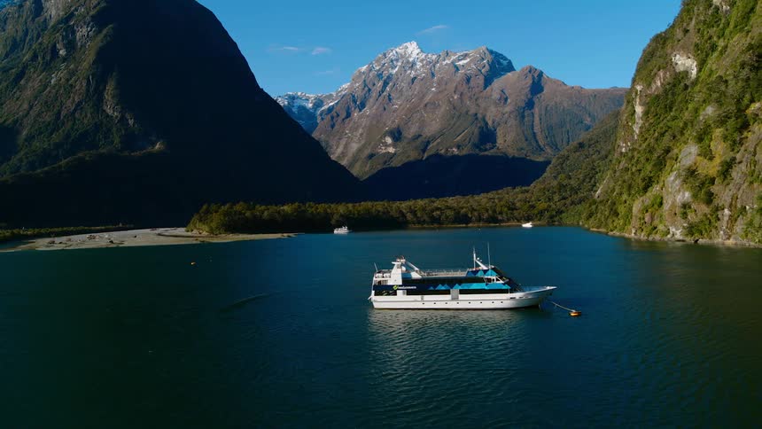 Aerial view of a passenger ferry over the calm surface of a lake on the mountains