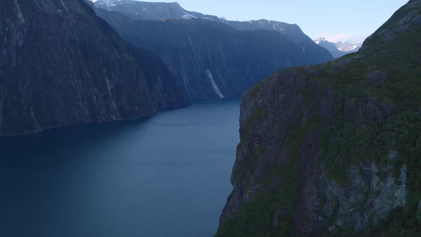 A wide river running between mountains on a clear day