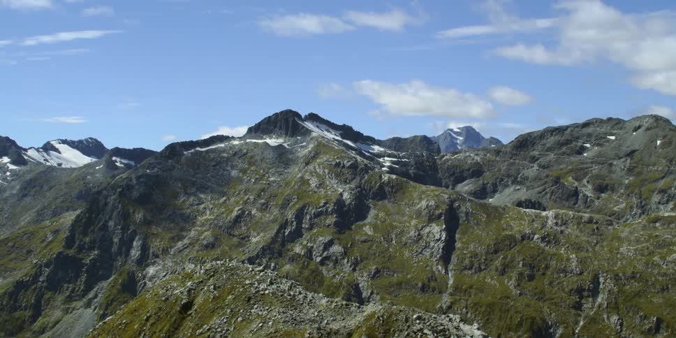 Aerial view of snow covered peaks in mountain range at day