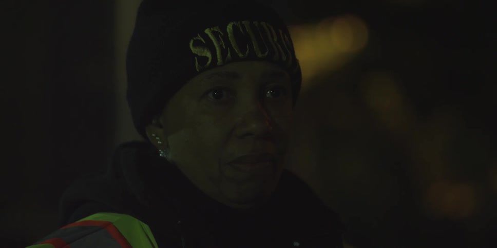 A woman is standing outside at night talking into a microphone