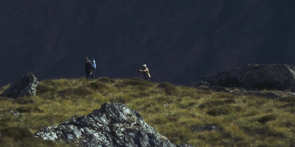 A family hikes through a mountainous area