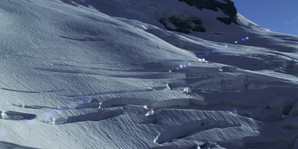 Aerial view of mountain slope covered in thick snow