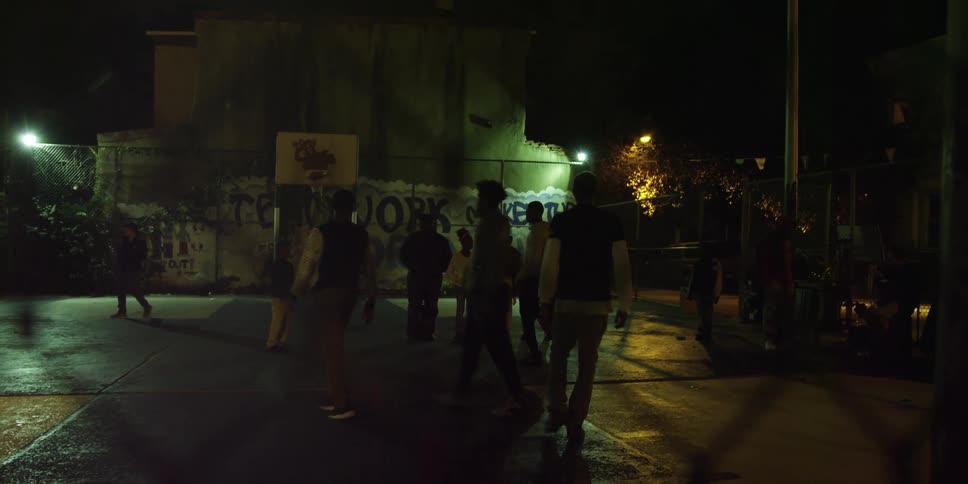 A group of kids playing basketball at night