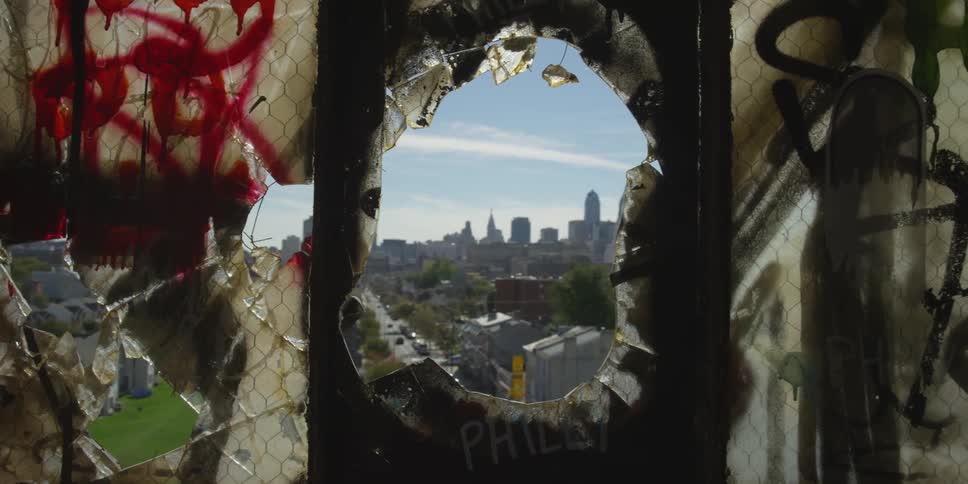 A town sits through a hole in the wall of a fence