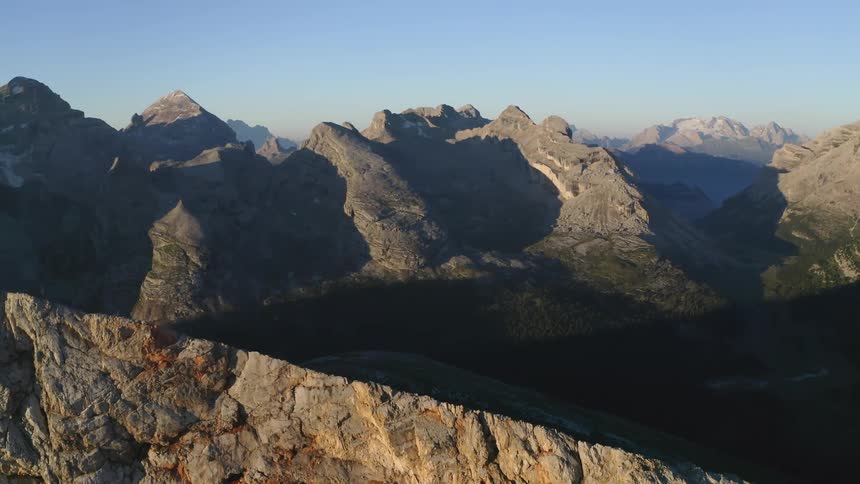A rock mountain range beneath a clear blue sky