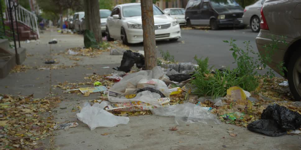 Debris blows in the wind on a sidewalk