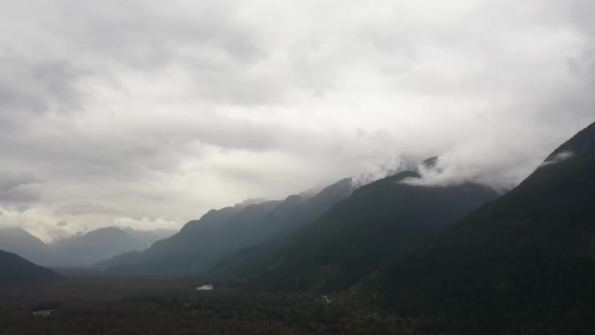 Mountains rise up into thick clouds