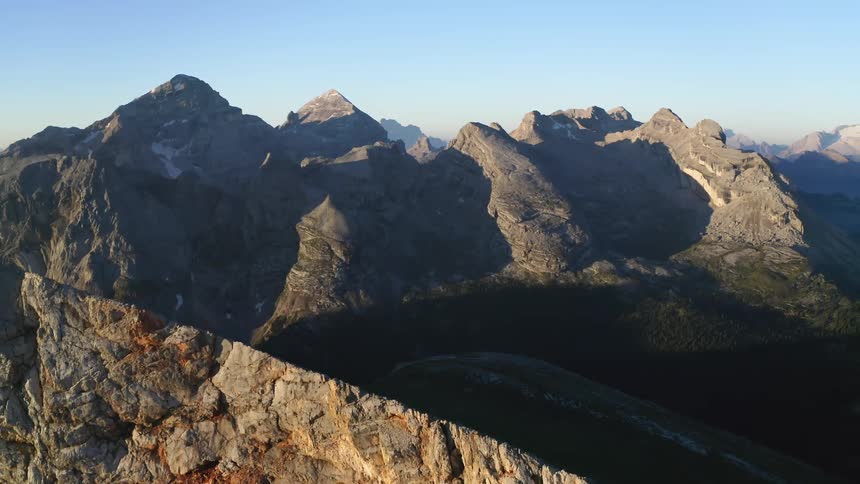 A small patch of snow remains on the highest mountain peak