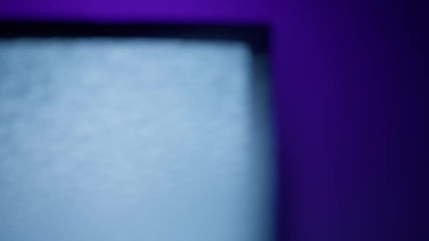 Static plays on a television screen against a blue wall