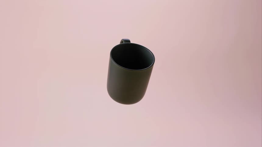 Dark colored mug rotates against a pink background