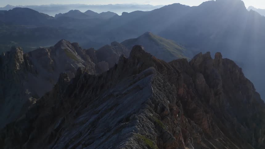 The sun shines on the peaks of the mountains