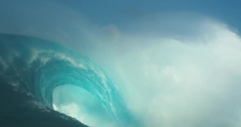 Big blue green ocean wave rolling crashes on a cloud of mist