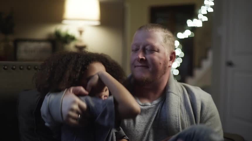 A man carries his daughter down the hall