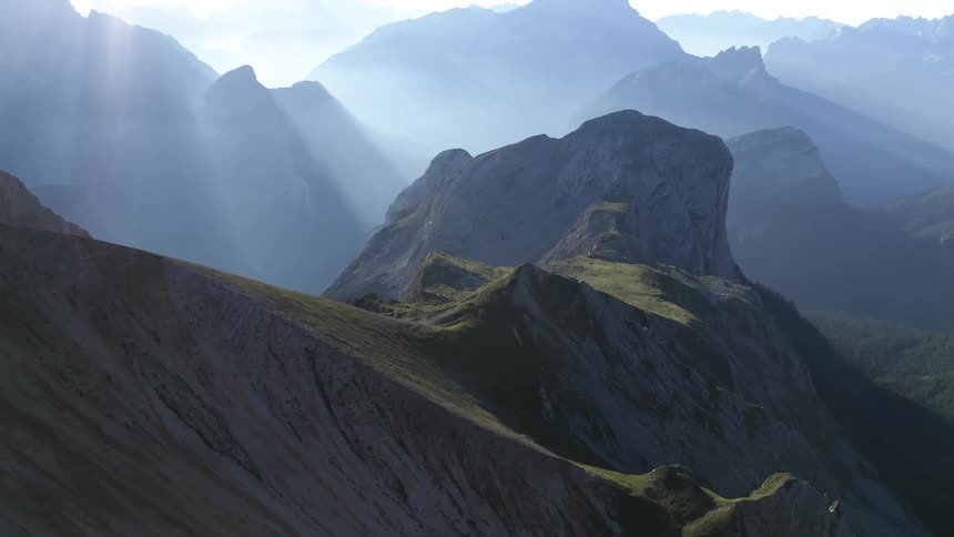 Beams of sunlight shine down upon a rocky mountain range