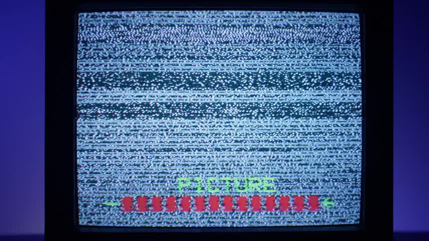 Static is displayed on an older television screen as menu options display at the bottom of the screen