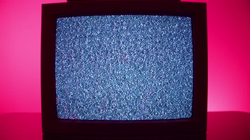 A crt television displays static in a room filled with pink lighting