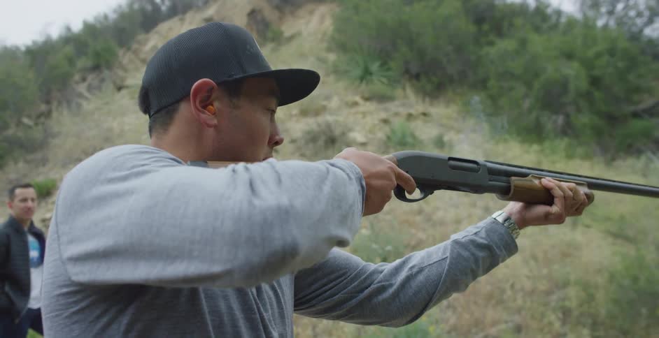 A view of a man shooting a shotgun