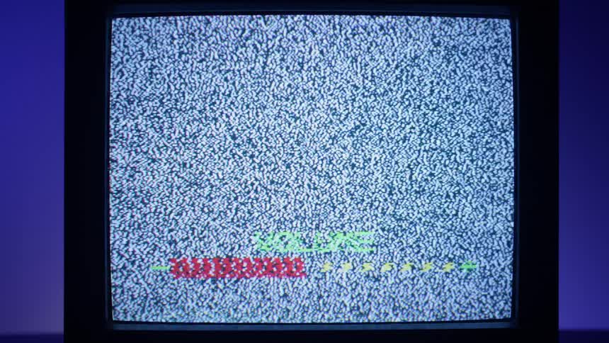 The volume is turned up as static plays on an old tube style television