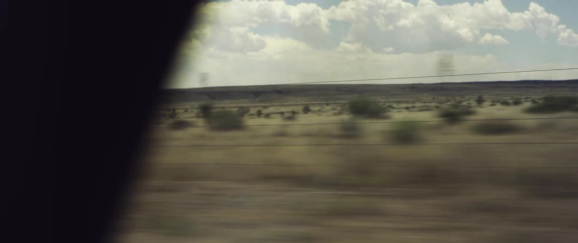 A car speeds through a desert landscape
