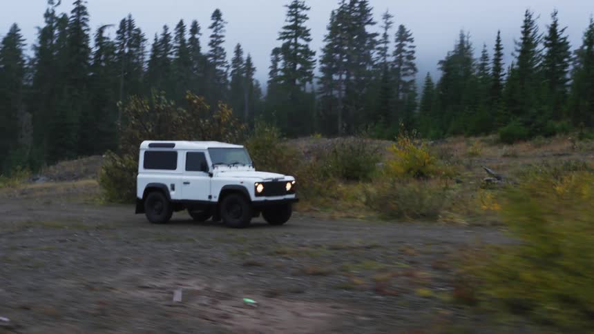 A vehicle is driving on a dirt trail outdoors