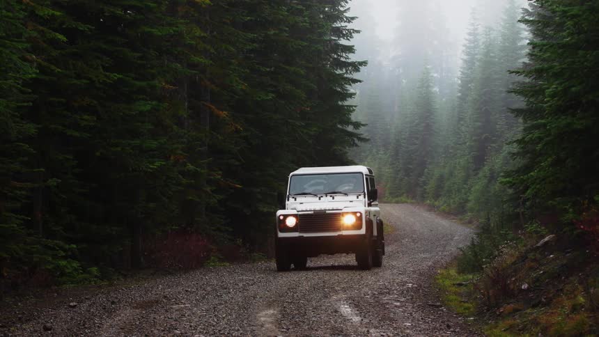 A view of a vehicle driving down a dirt road