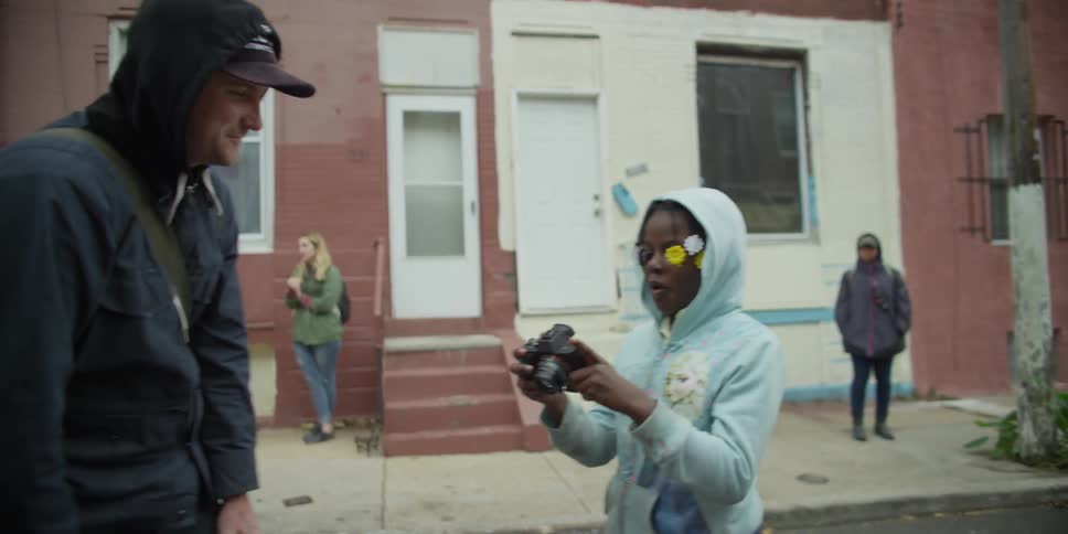 A girl takes a photograph of a man and they check the camera