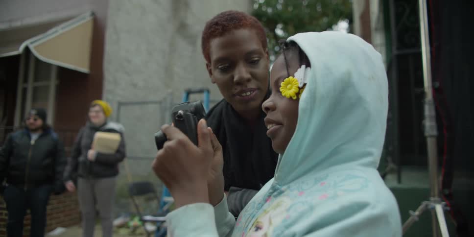 A girl in a blue hoodie takes a picture
