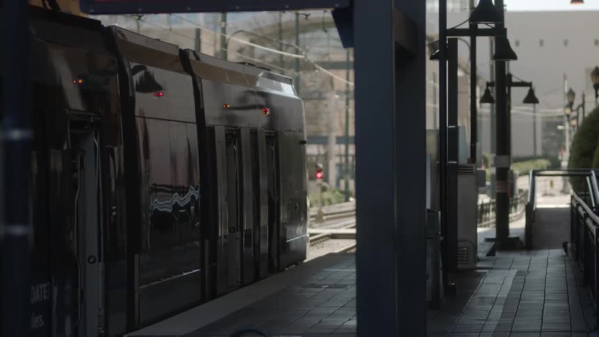 A passenger train waits at a platform for passengers to get on