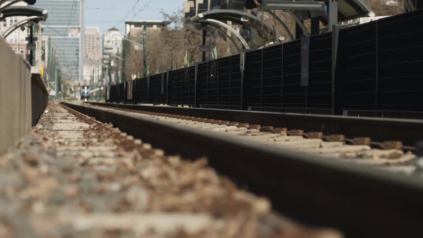 Cars are driving past the train tracks
