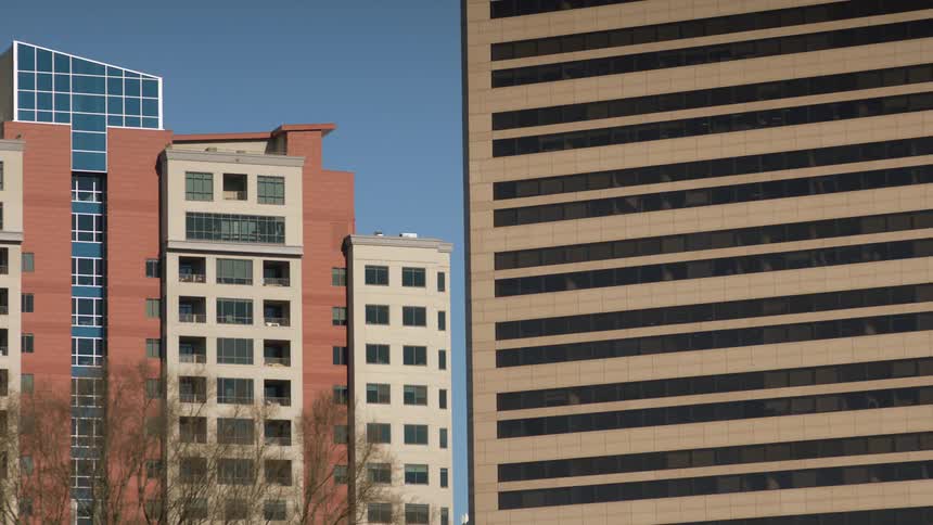 The two tall buildings fill the clear sky