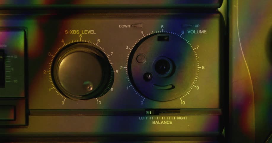 Moving shadows are cast upon an older stereo that is missing a knob