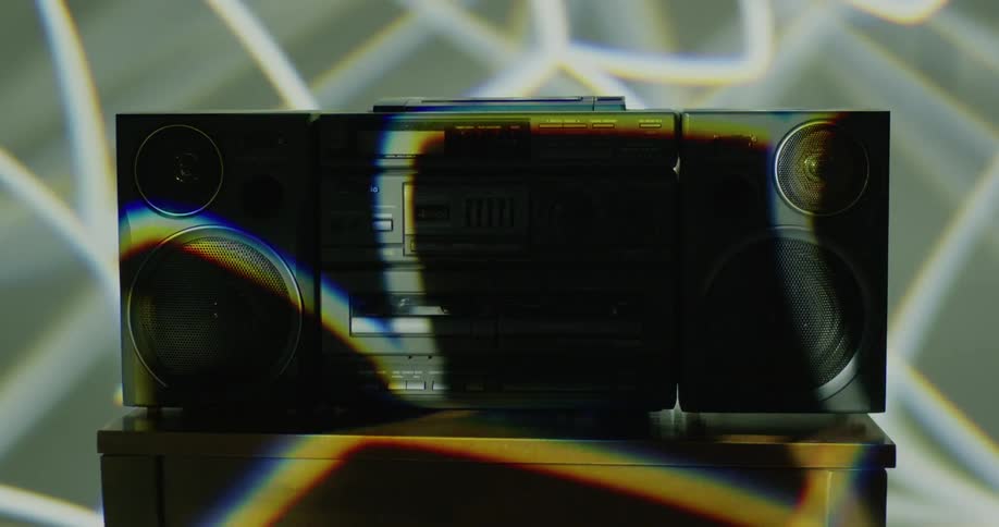 Lights flash on an old fashioned boom box that is sitting on a wooden table