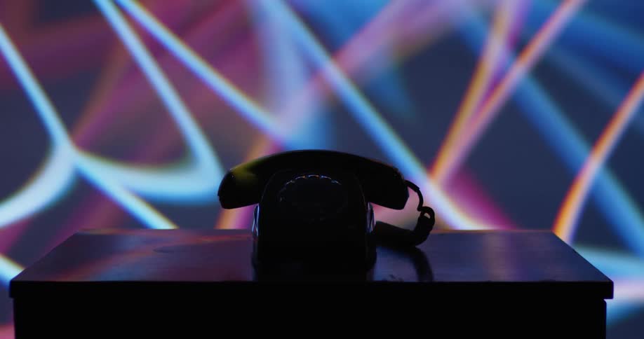 Lights flash around a rotary phone on a table