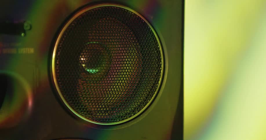 Moving shadows are cast upon an stereo speaker of a boombox
