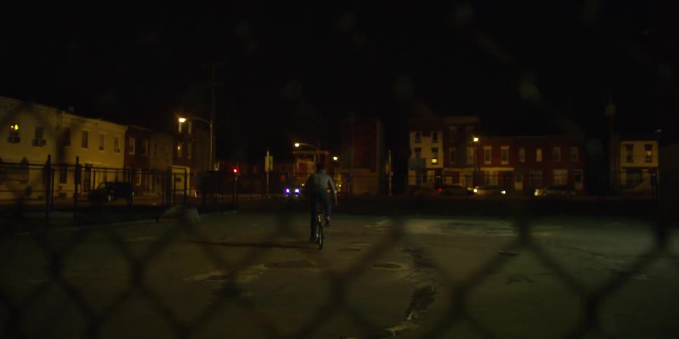 A man rides a bike in a parking lot