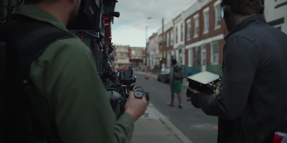 A person films a kid playing with a basketball