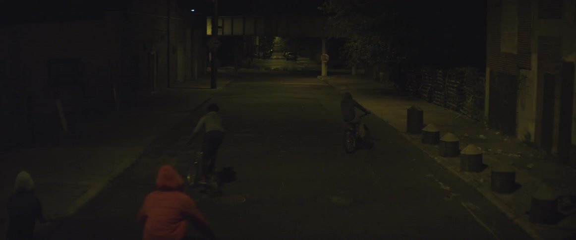 People are riding bikes down a street at night