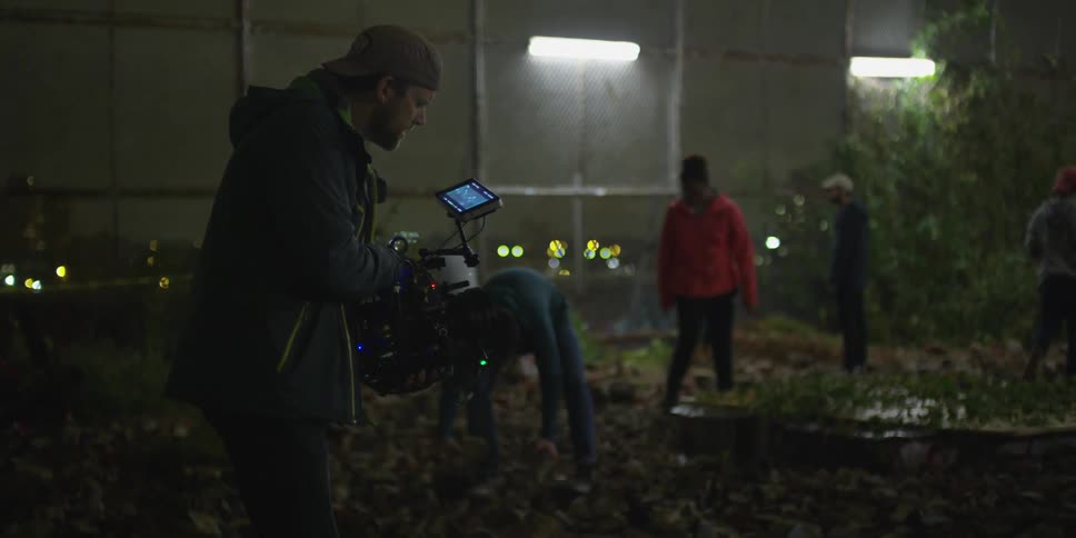 A man is filming people at night