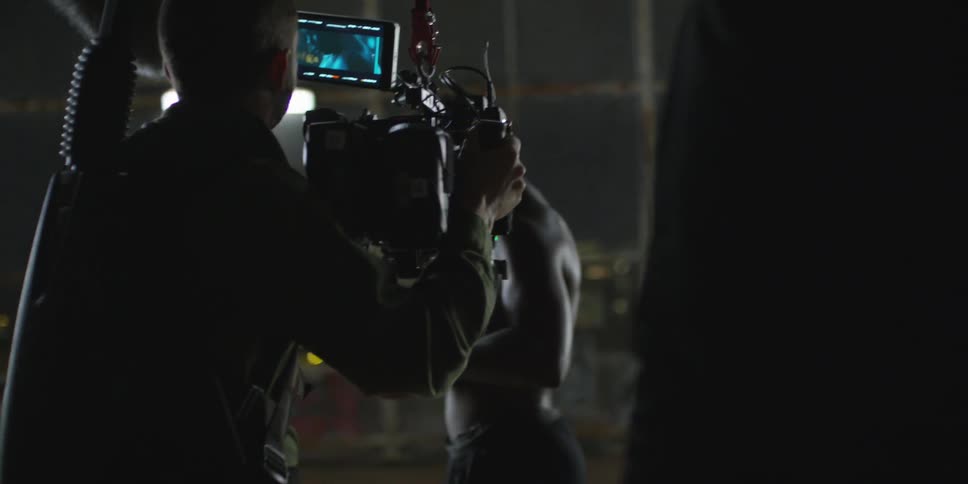 A film crew if filming a man holding a basketball