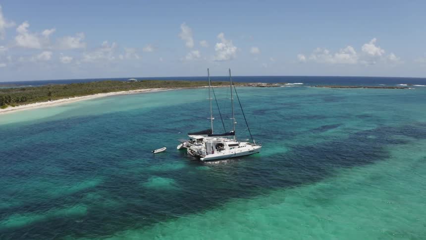 Two boats are anchored near the islands