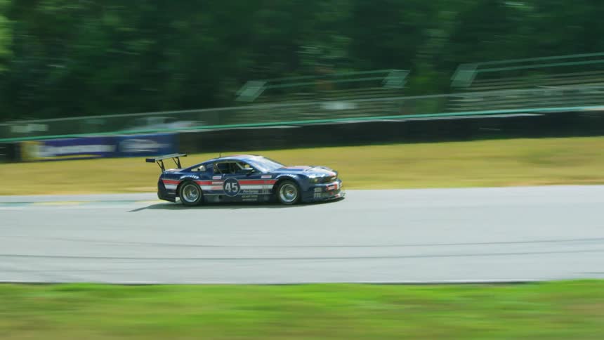 A race car travels an outdoor rural race track