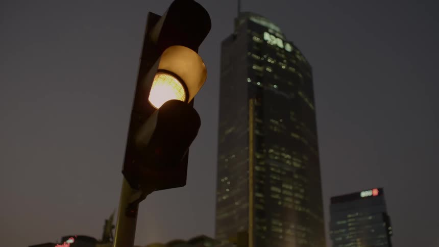 A traffic light downtown changes from green to yellow