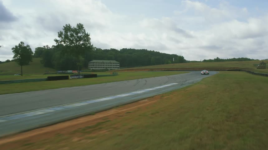 A single white race car speeds around a track
