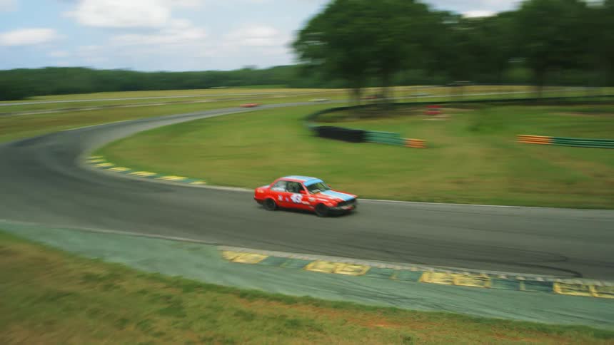Race cars are turning around the track