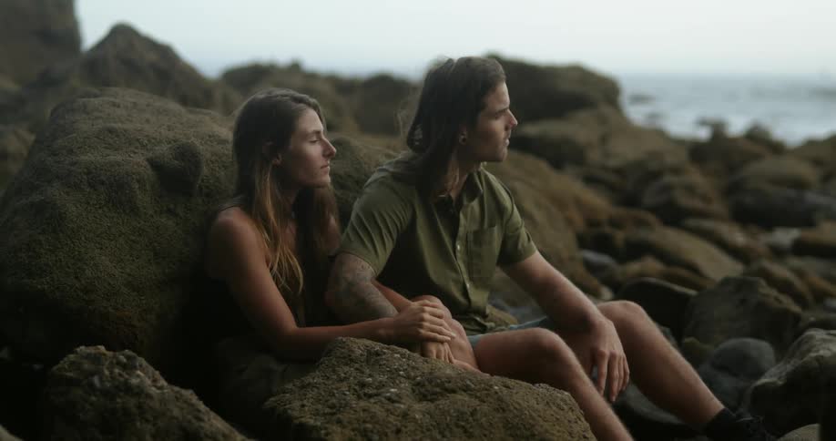 A boyfriend and girlfriend sitting on the beach